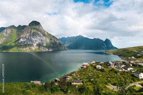 Scenic landscape on Lofoten islands with great mountains near green water. Beautiful rainbow 