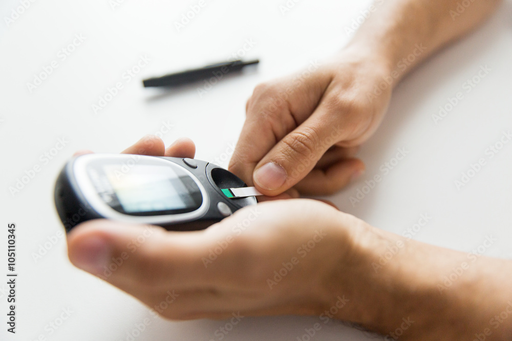 close up of man checking blood sugar by glucometer close up of man checking blood sugar by glucometer