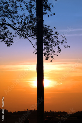 Sun set behind tall pole
