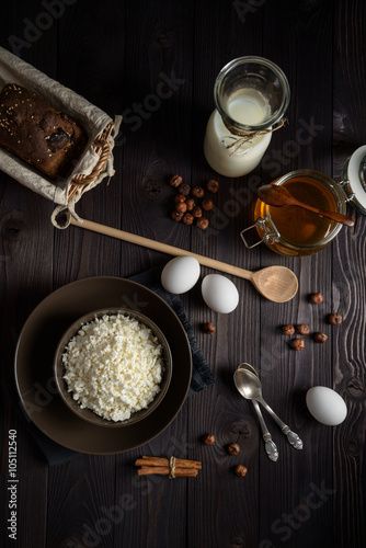 cottage cheese in a brown bowl on a dark wooden background