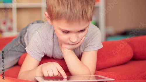 little boy playing on the tablet computer games