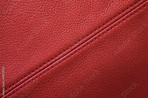 Red leather background with sewing seam