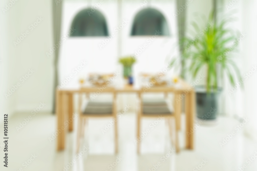 blurred dining table and chairs with elegant table setting for background