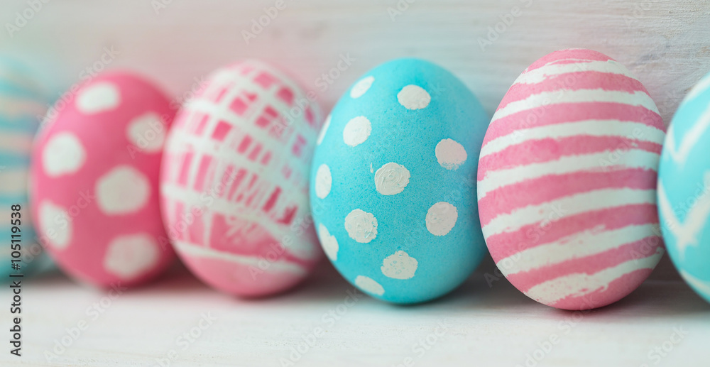 Fototapeta premium Pink and blue easter eggs on a wooden background
