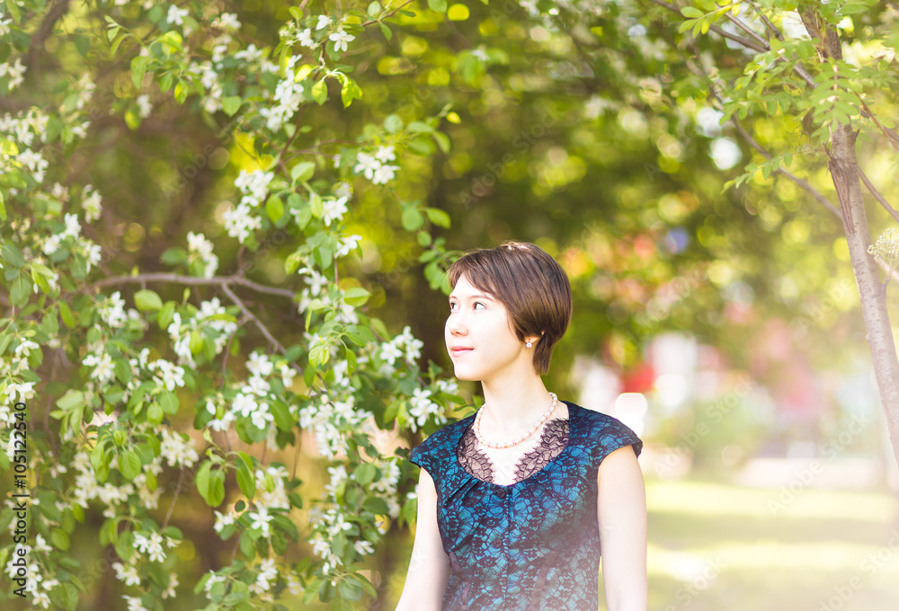 Beautiful young asian woman in flowering spring garden. Beautiful young asian woman in flowering spring garden.