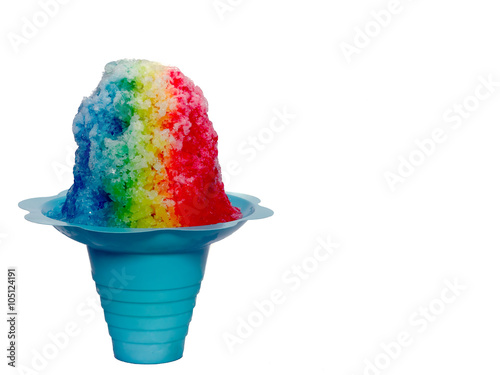 Hawaiian Rainbow Shaved ice, shave ice or a snow cone in a blue flower shaped cup against a white background.