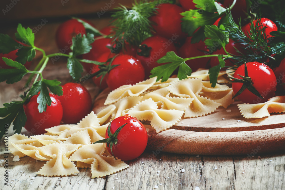 Italian dry pasta farfalle in the form of bows with cherry tomat