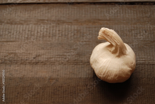 Bulb of garlic on brown wooden background - close-up