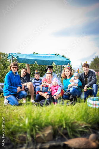 Happy family smiling at camera at birthday party outside at picnic © emaria