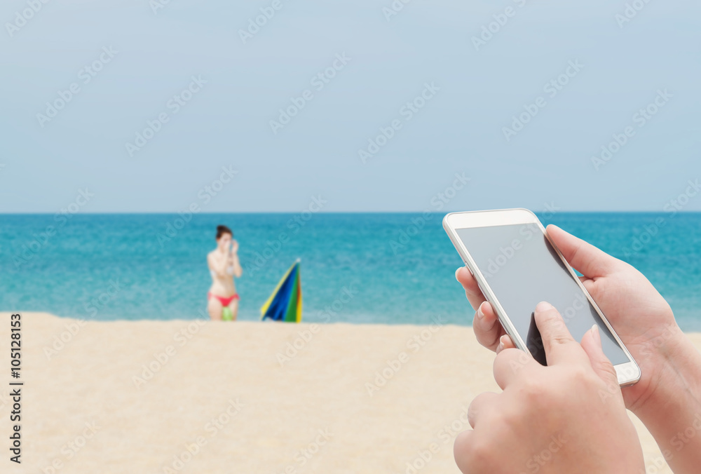 Women using smartphone top on blurred blue sea