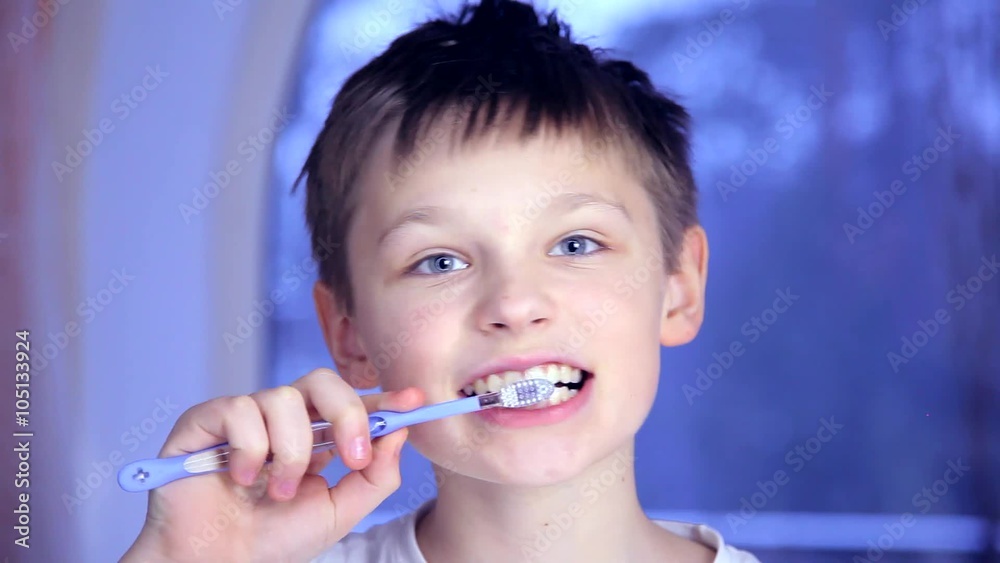 A boy on a blue background brushing his teeth A boy on a blue background brushing his teeth