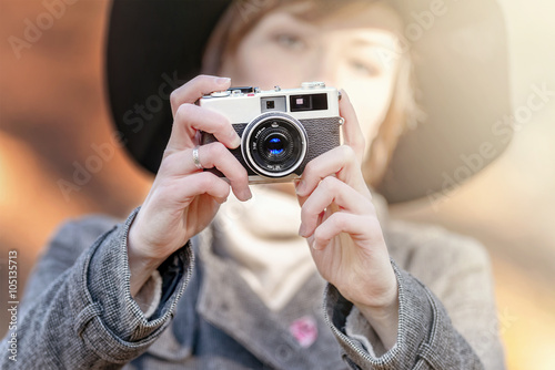 Female photographer takes a snapshot with a old retro camera