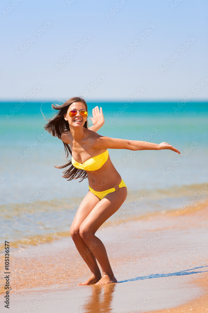 Naklejka premium brunette woman yellow bikini jump sea