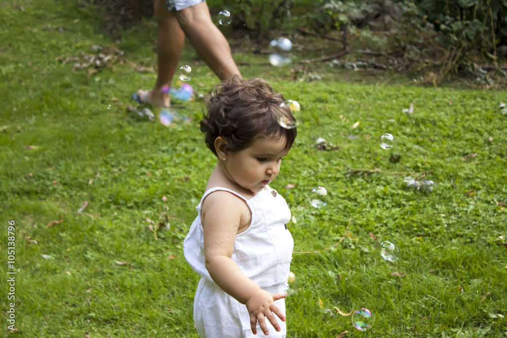 Girl playing with soap bubbles in the garden Girl playing with soap bubbles in the garden