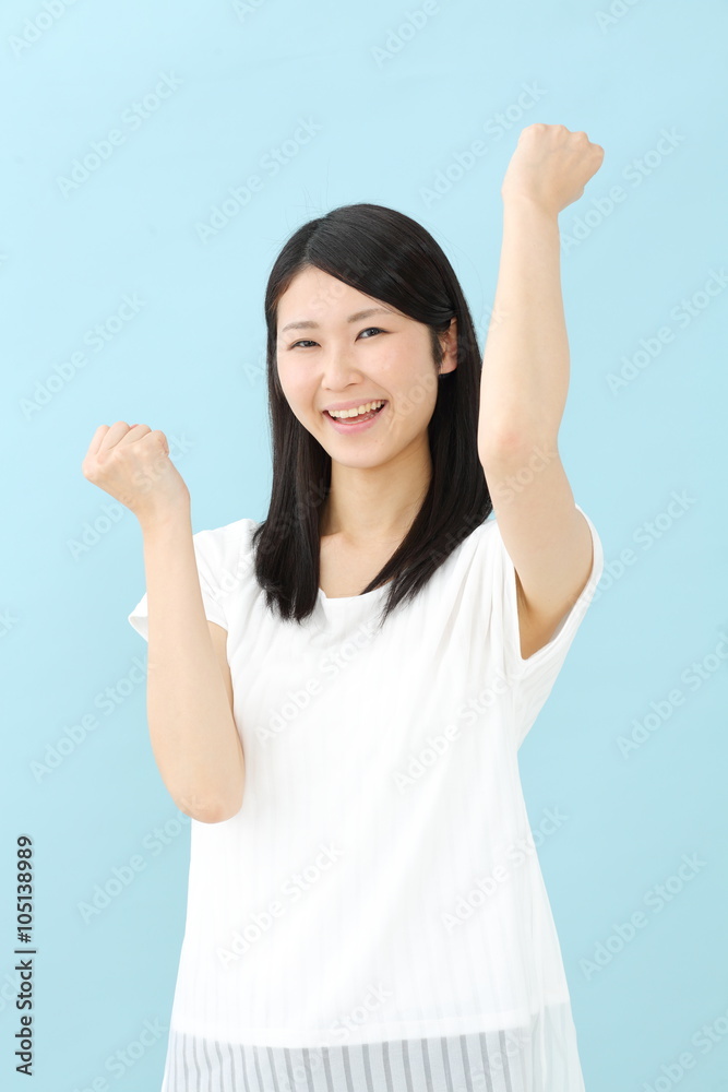 ガッツポーズ・若い女性・ブルーバック ガッツポーズ・若い女性・ブルーバック