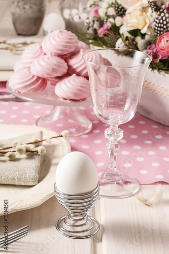 White egg and pink meringues on the easter table
