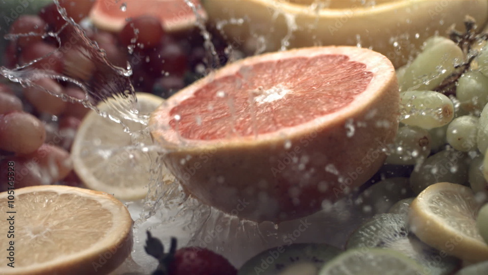 Grapefruit splashing into water, slow motion