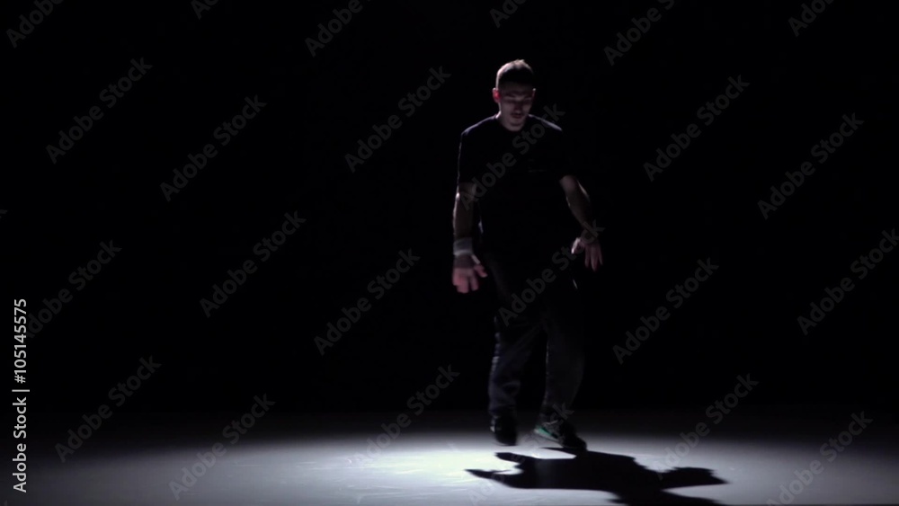Dancer in dark suit dancing breakdance, on black, shadow, slow motion Dancer in dark suit dancing breakdance, on black, shadow, slow motion