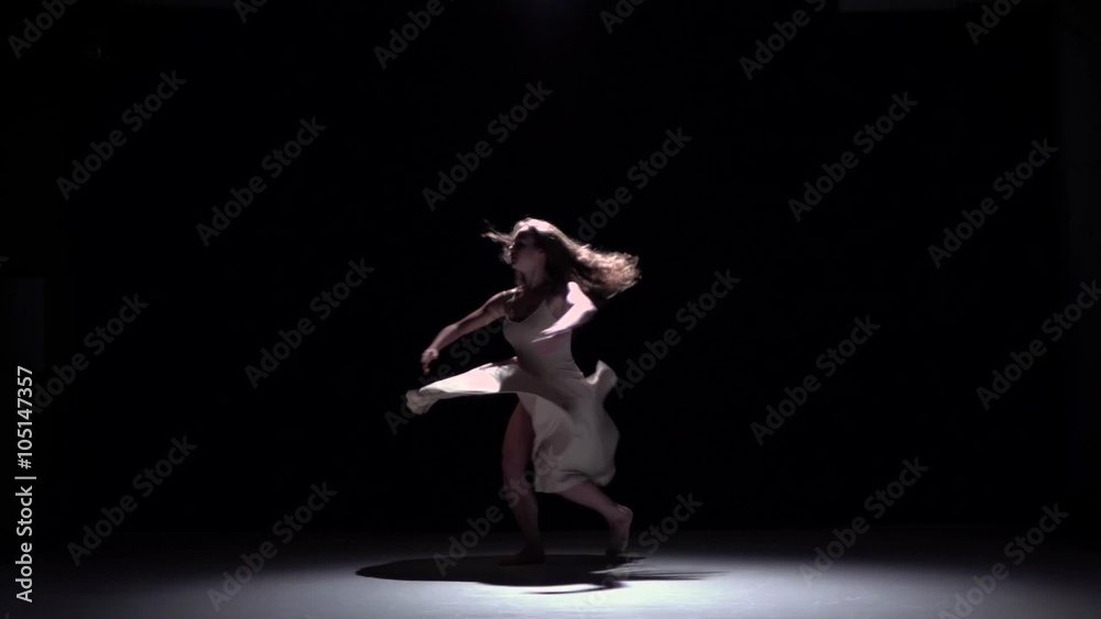Modern dancer girl in white starts dancing contemporary, whirls on black, shadow, slow motion Modern dancer girl in white starts dancing contemporary, whirls on black, shadow, slow motion