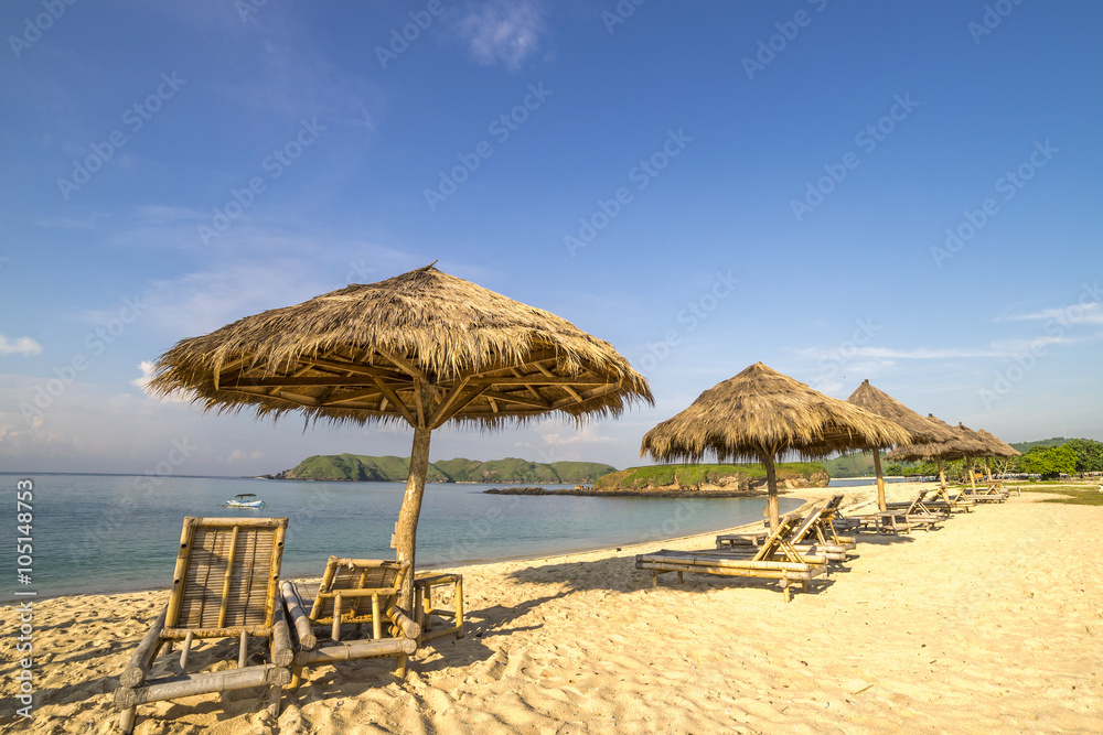 A row of wooden lounge with direct sunlight at Lombok beach, Indonesia