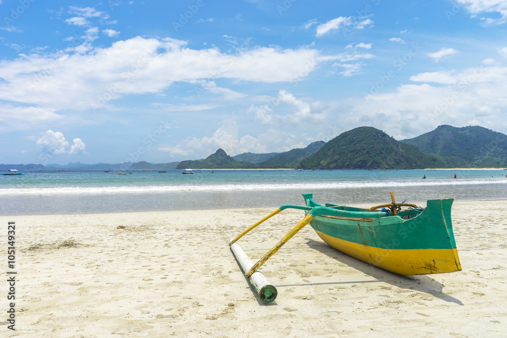Traditional wooden boat park at sea shore with cloudy skies at South Lombok island, Indonesia Traditional wooden boat park at sea shore with cloudy skies at South Lombok island, Indonesia