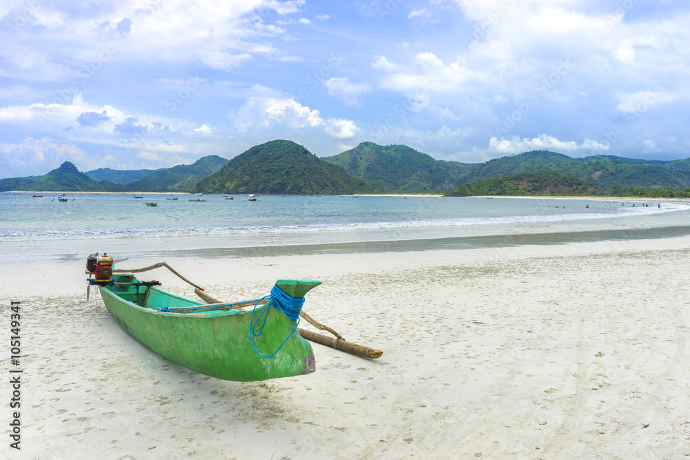 Traditional wooden boat park at sea shore with cloudy skies at South Lombok island, Indonesia Traditional wooden boat park at sea shore with cloudy skies at South Lombok island, Indonesia