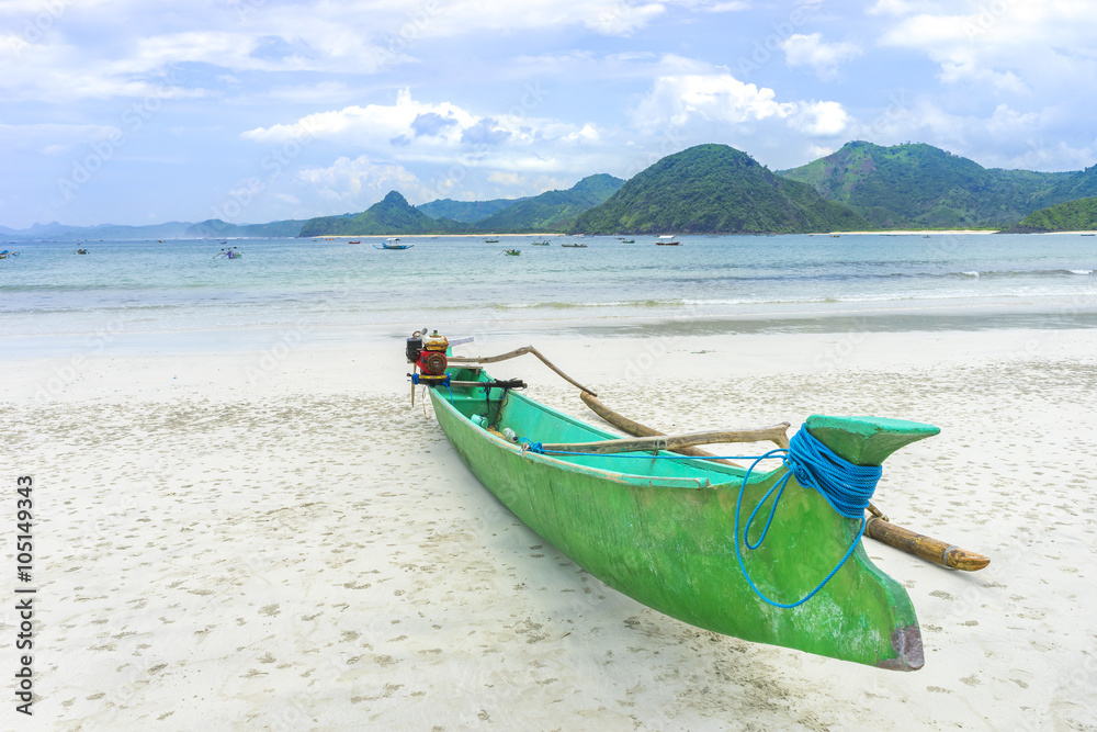 Traditional wooden boat park at sea shore with cloudy skies at South Lombok island, Indonesia Traditional wooden boat park at sea shore with cloudy skies at South Lombok island, Indonesia