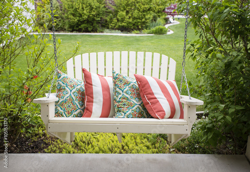 Photography Beautiful wooden front porch swing with comfortable pillows