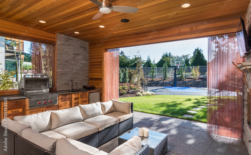 Beautiful covered patio outside new luxury home with television ...