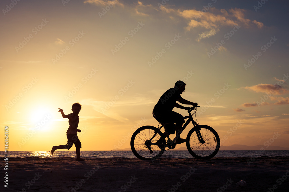 Father and son playing on the beach at the sunset time. Father and son playing on the beach at the sunset time.