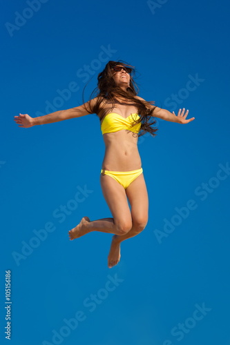 brunette woman yellow bikini jump sky