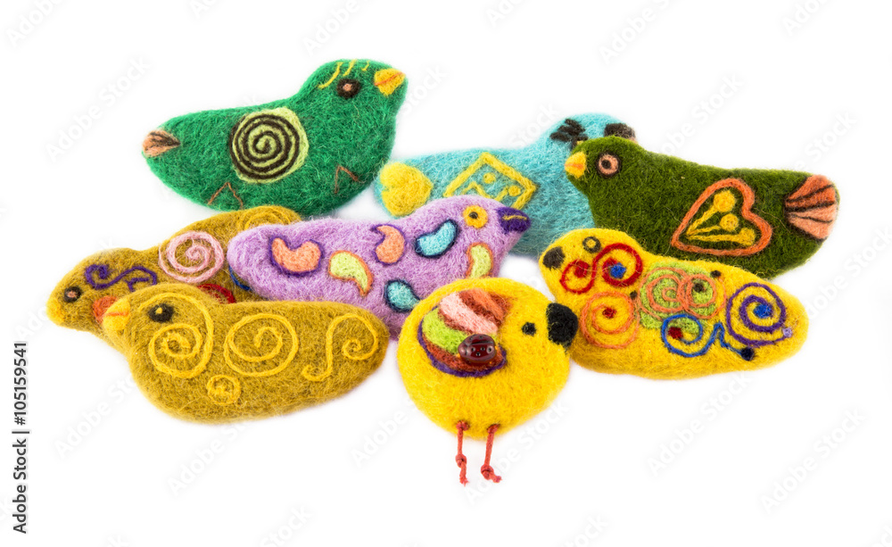 Obraz premium Броши из валяной шерсти в виде птичек на белом фоне 