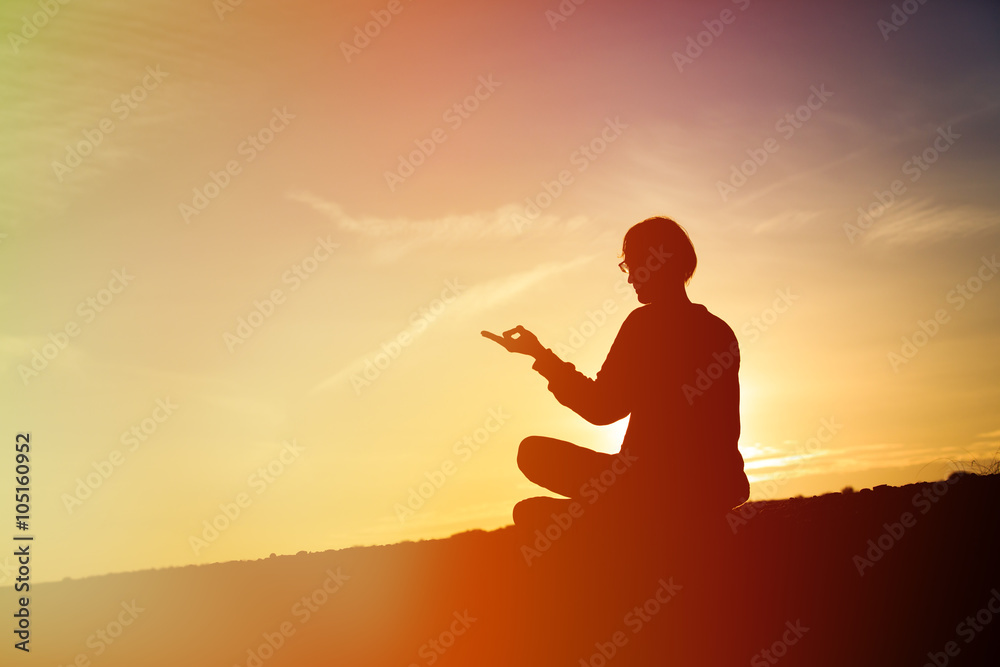 man doing yoga at sunset sky