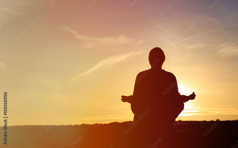 man doing yoga at sunset sky