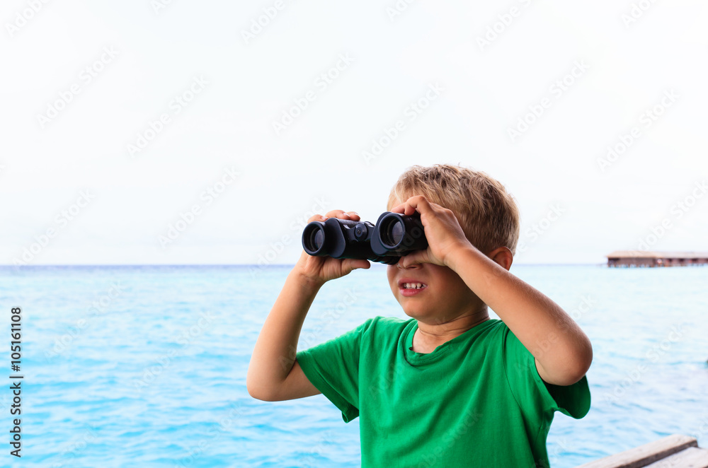 Obraz premium little boy with binoculars travel at sea 