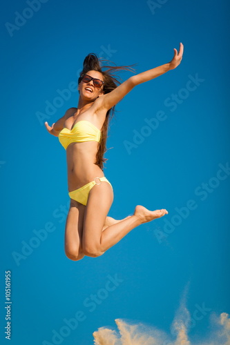 brunette woman yellow bikini jump sky