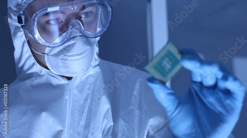 Man in clean room holds up computer cpu microchip