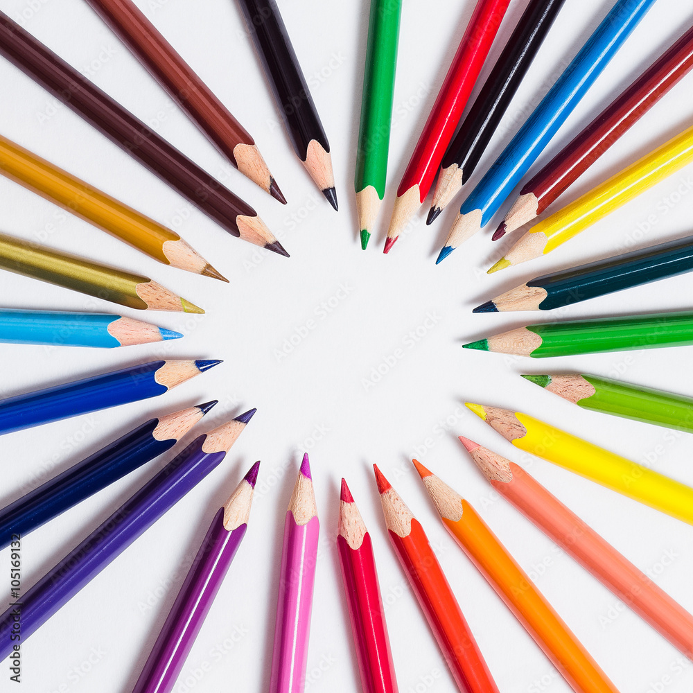 Colored pencils are lying in a circle on a white background