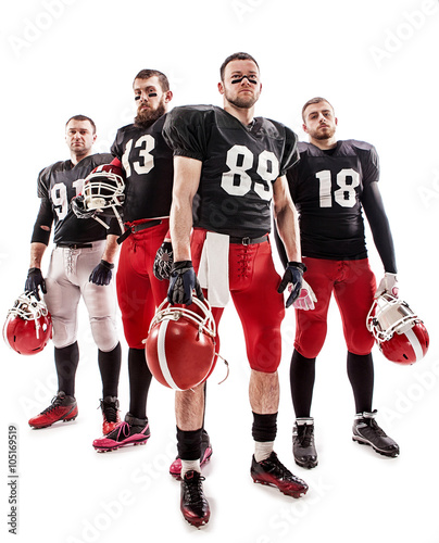 The four american football players posing with ball on white background