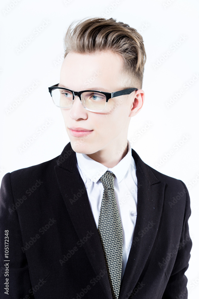 Close up picture of an elegant young fashion man wearing black suit on gray background
