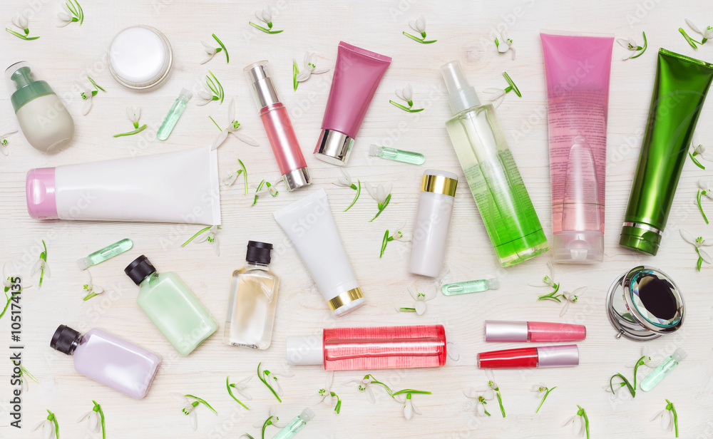 Spring set of cosmetics, laid out on a white wooden background w