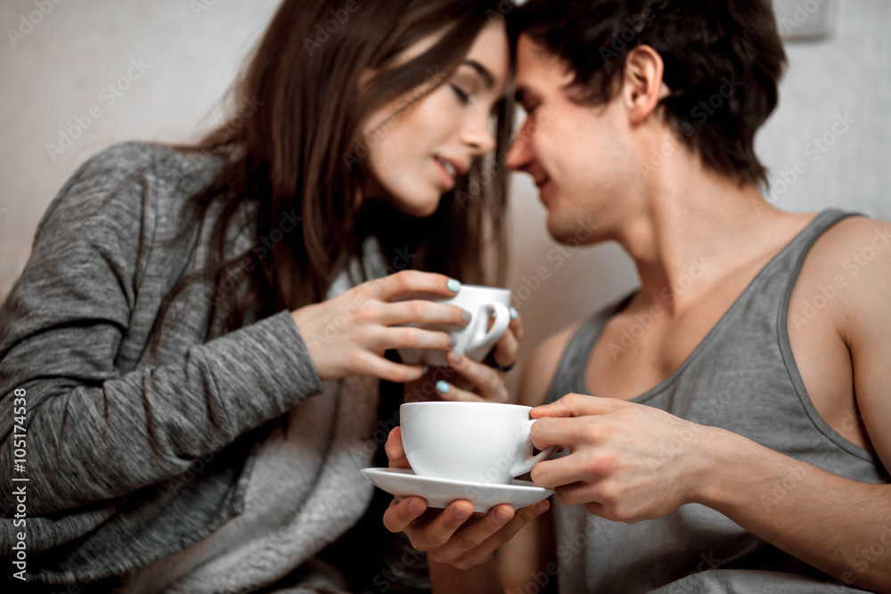 Young beautiful pair of lovers drink tea (coffee) in bed Young beautiful pair of lovers drink tea (coffee) in bed
