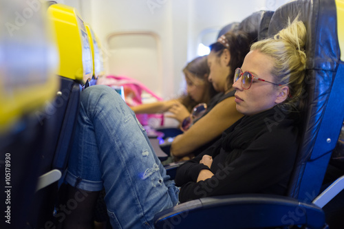 Tired lady napping on airplane.