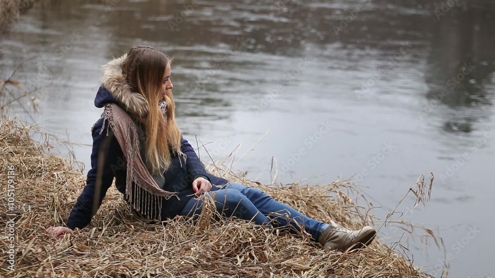 The girl with long hair, sitting in the water on the river bank