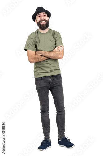 Carefree spontaneous laughing hipster with crossed arms. Full body length portrait isolated over white studio background.