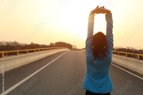 fitness sports woman runner stretching on sunrise city road