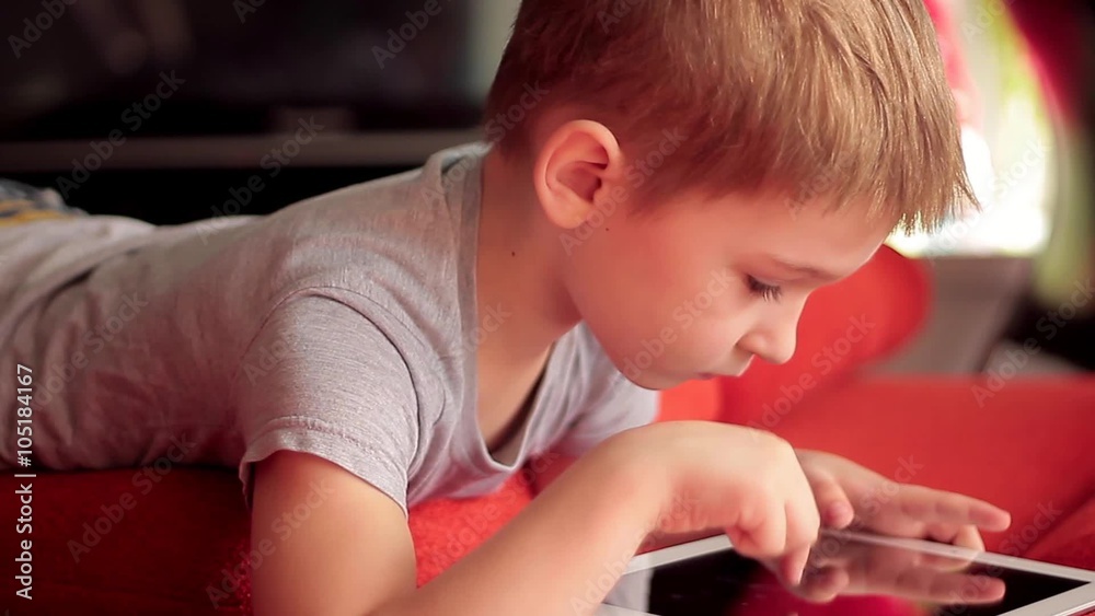 little boy playing on the tablet computer games little boy playing on the tablet computer games