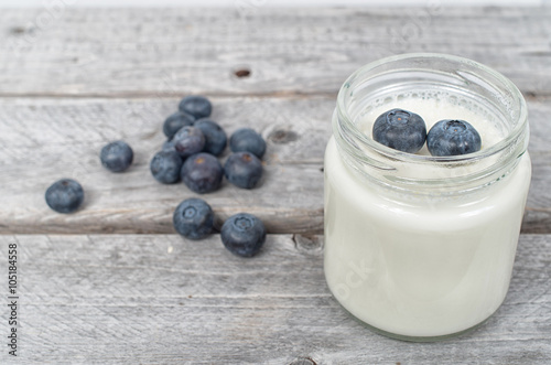 Homemade natural yogurt with blueberries fruits on a wooden tabl