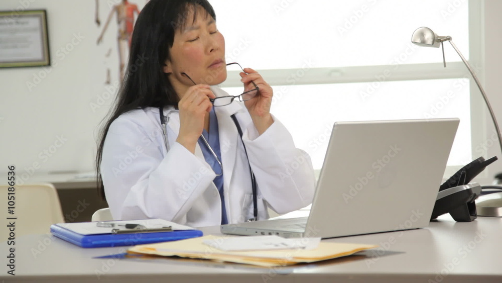 Doctor working at desk with laptop computer Doctor working at desk with laptop computer