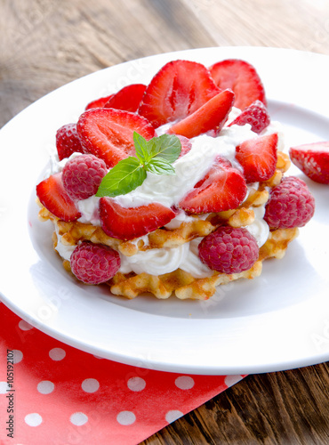 Belgian waffles with strawberries,raspberries and cream.